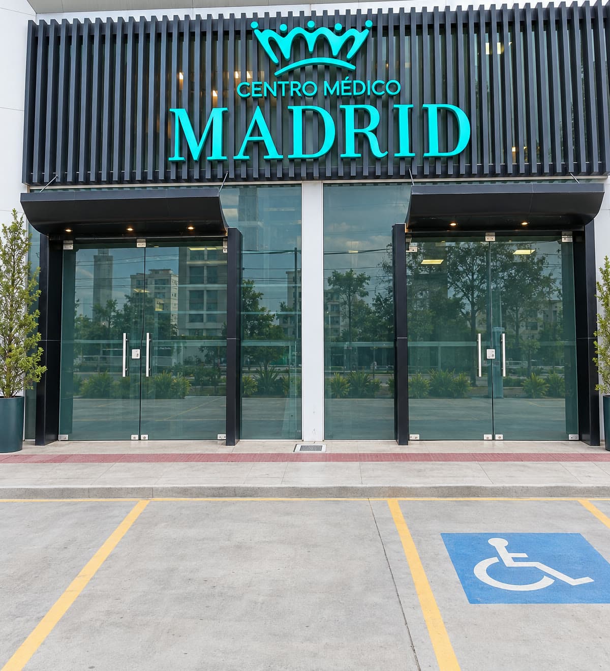 Fachada da sede nova com o letreiro Centro Médico Madrid em turquesa e portas de vidro