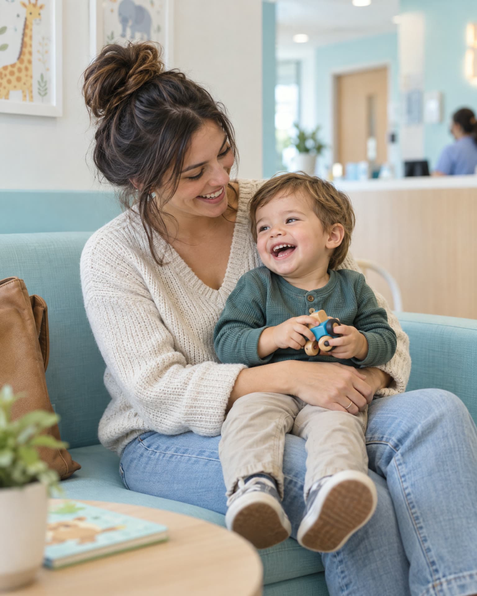 Mãe sorrindo com o filho pequeno no colo na sala de espera